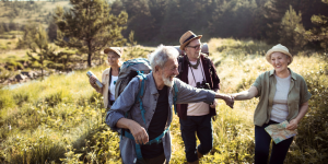Personas adultas realizan una ruta de senderismo para personas mayores de 60 en Valencia mientras se divierten.